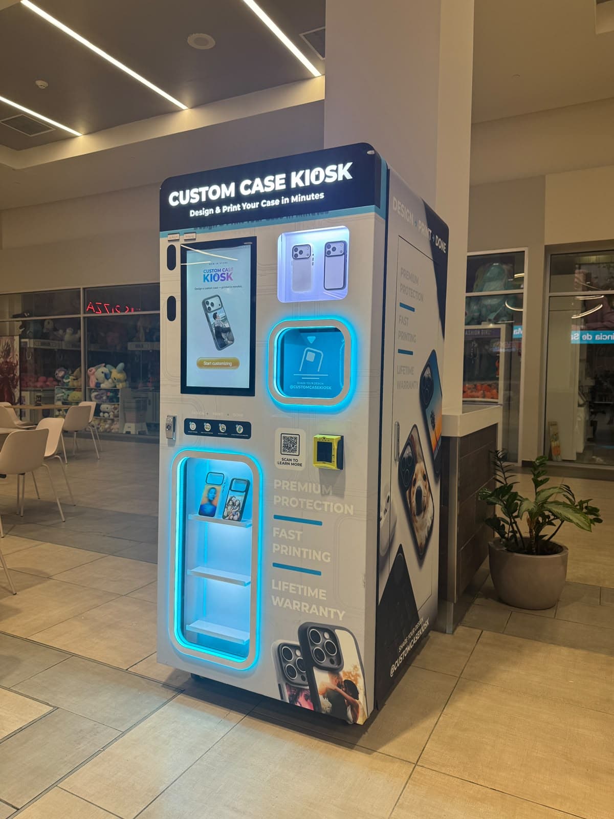 Custom Case Kiosk inside Plaza Centro Mall in Caguas, PR — full view of the kiosk beside a mall column, with the lit marquee, design touchscreen and case display
