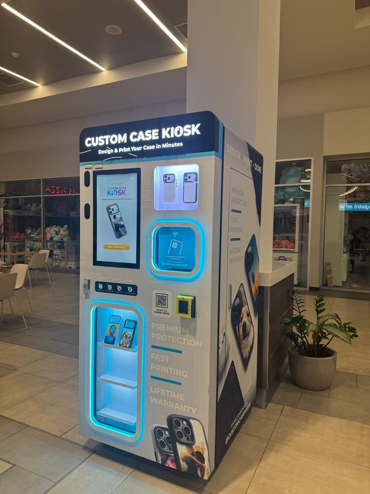 Custom Case Kiosk at Plaza Centro Mall in Caguas, PR — three-quarter view showing the touchscreen, the pickup window and the Design, Print, Done side panel