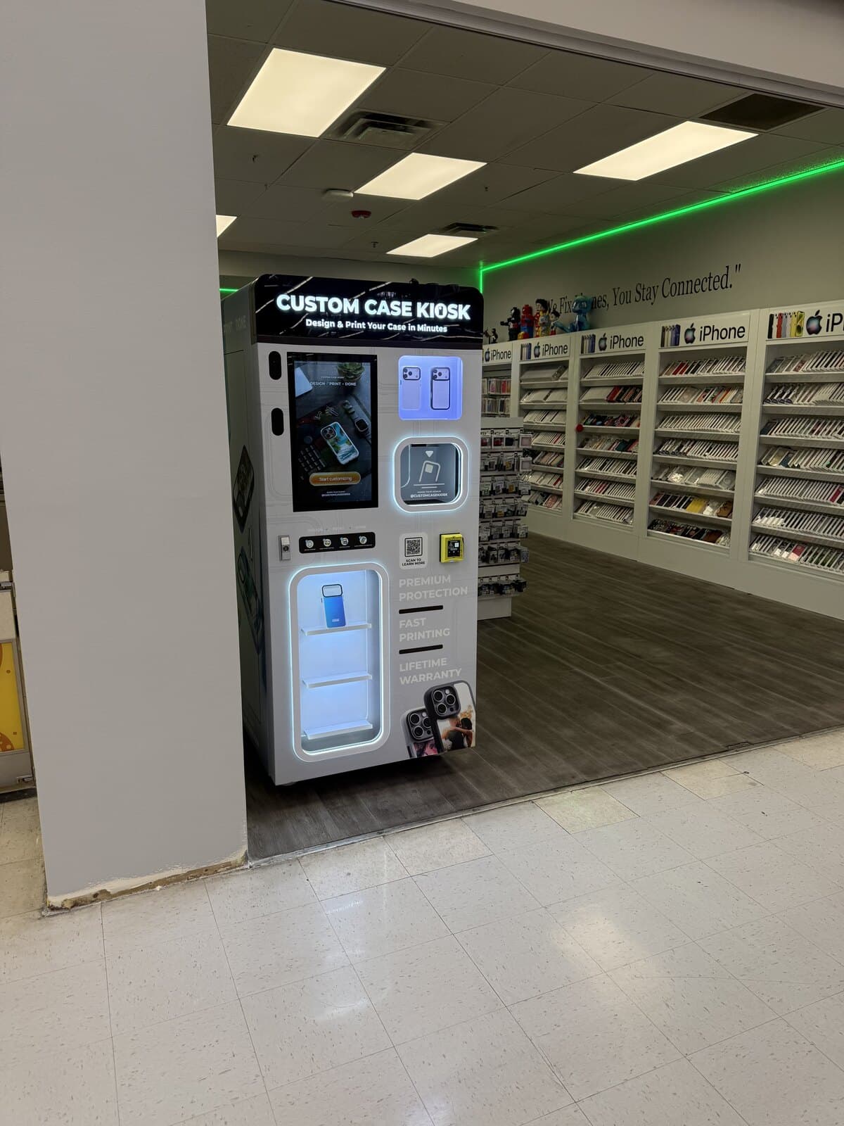 The Custom Case Kiosk just inside the iFix and Repair entrance in Chino, with the store's phone case wall visible behind it