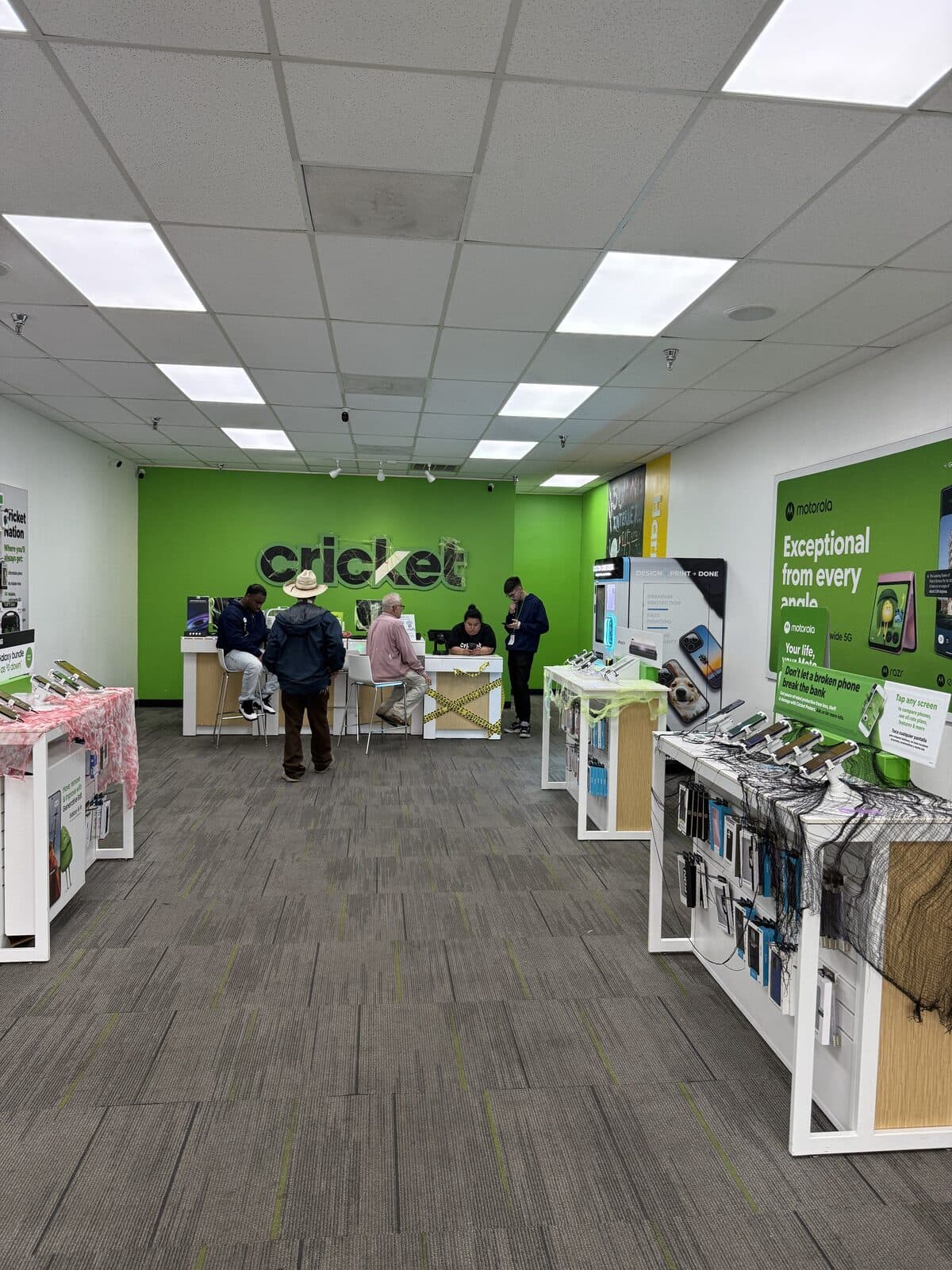 Inside the Cricket Wireless store at 6852 Harrisburg Blvd, Houston, TX — the sales counter under the green Cricket wall, with the Custom Case Kiosk at the right