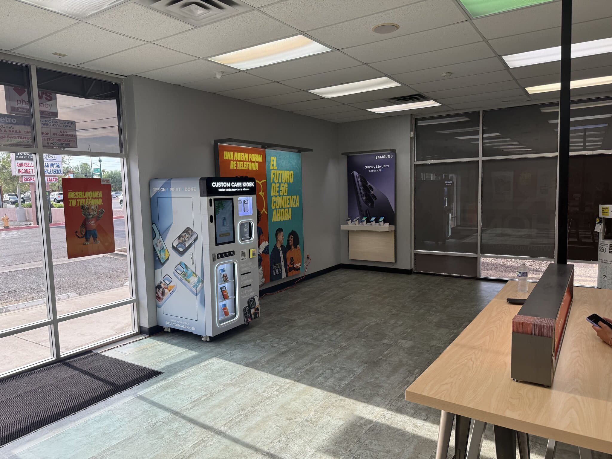 Boost Mobile store interior in Maryvale, west Phoenix, with the Custom Case Kiosk by the front windows near the service counter