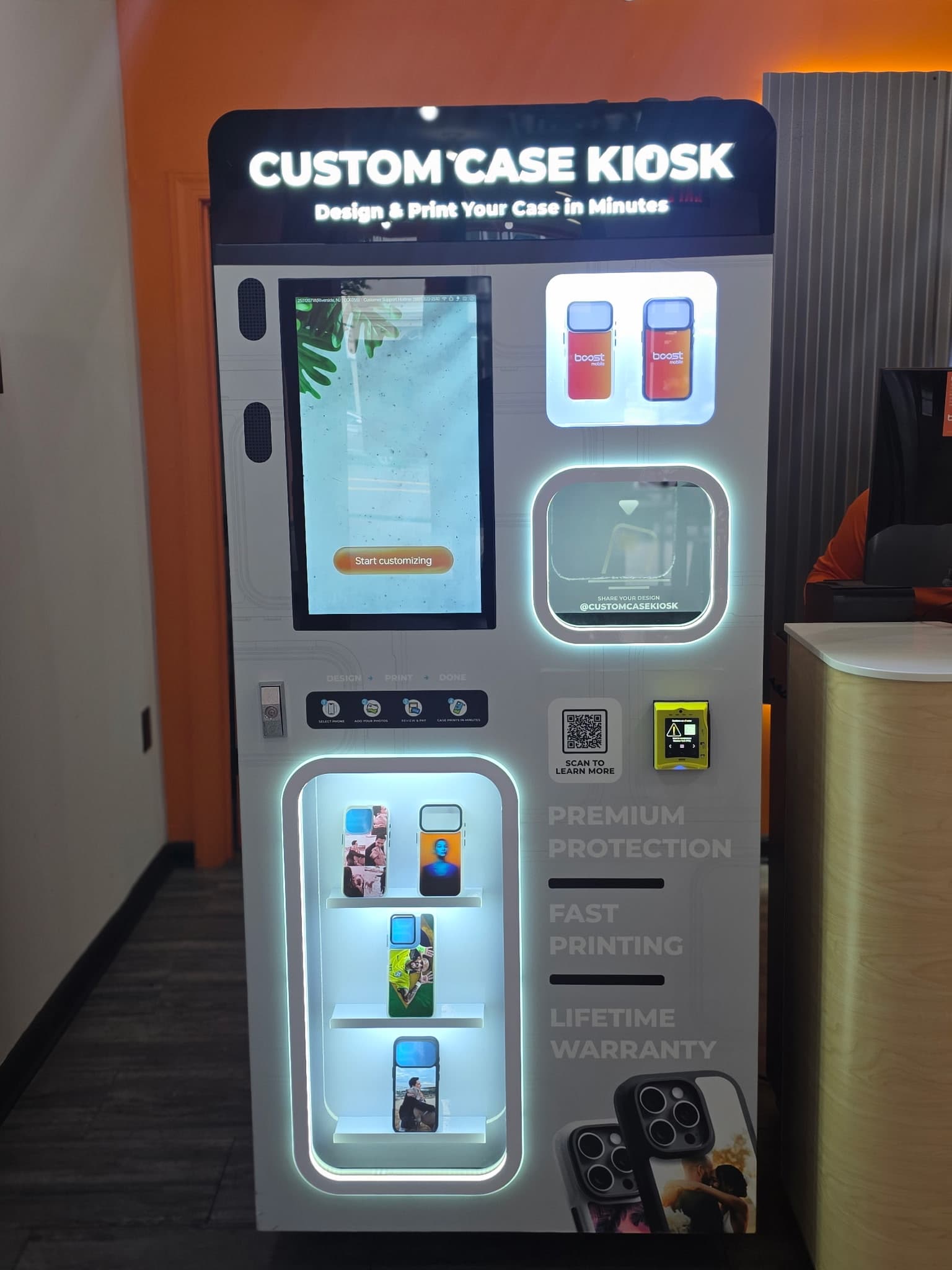 Custom Case Kiosk in Riverside, NJ — attract screen, Boost Mobile case display, and backlit case shelves