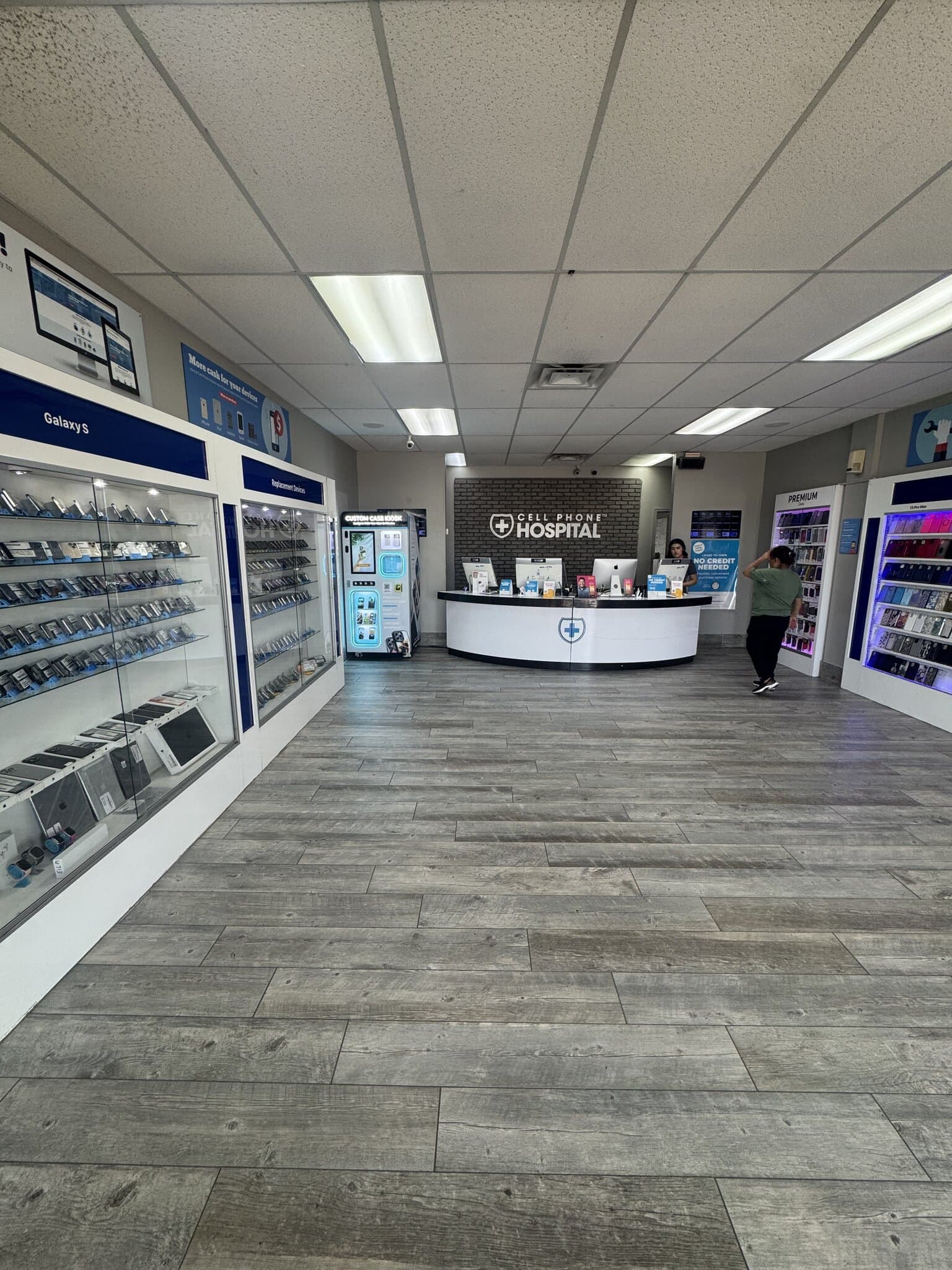 Inside Cellphone Hospital in east Tulsa, OK — the Custom Case Kiosk stands beside the accessory cases across from the service counter
